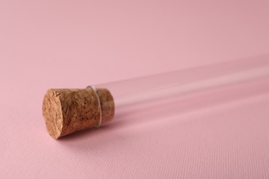 Photo of Test tube on pink background, closeup. Laboratory glassware