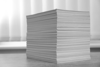 Photo of Stack of paper sheets on grey table