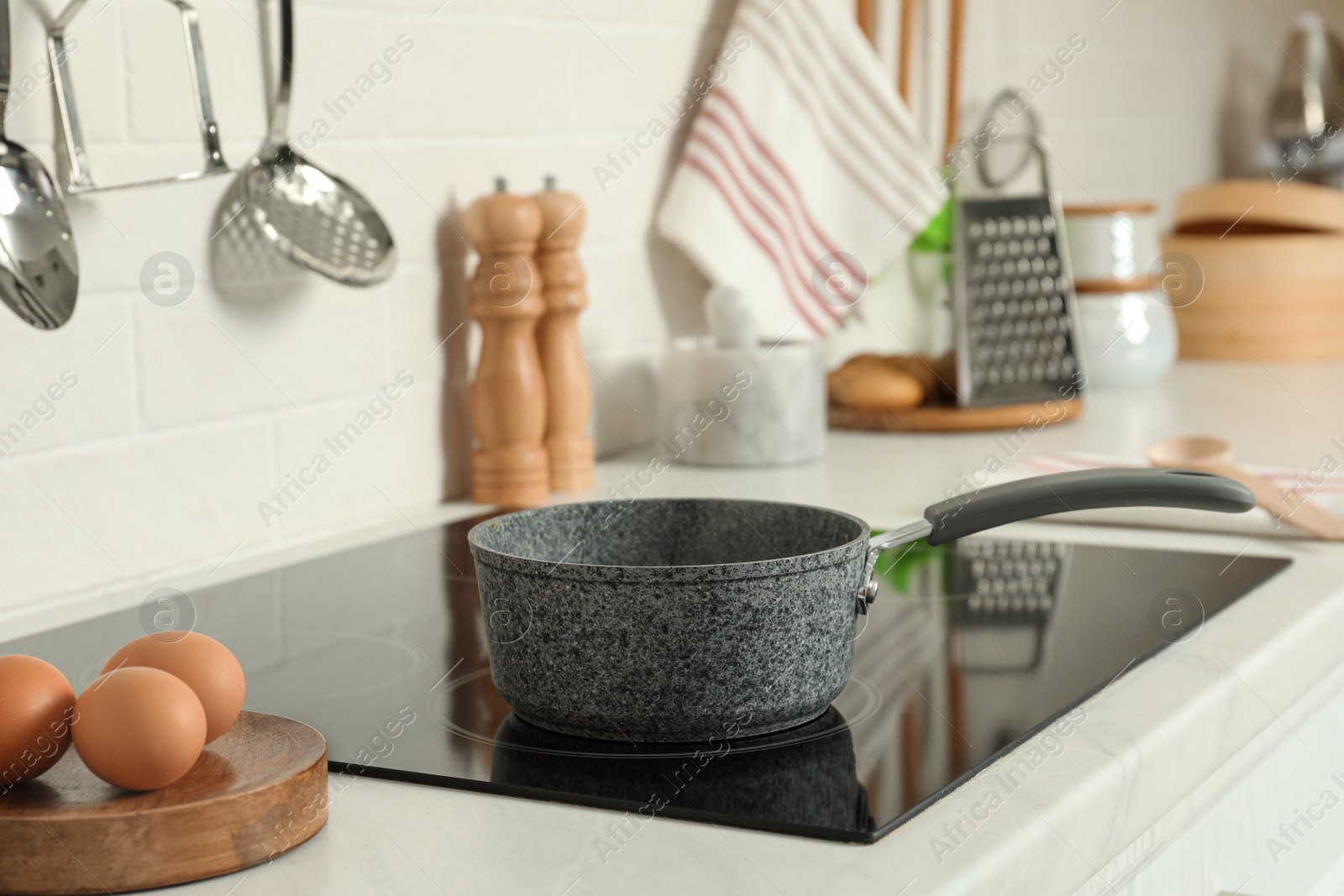 Photo of Saucepan on electric stove in kitchen. Cooking utensil