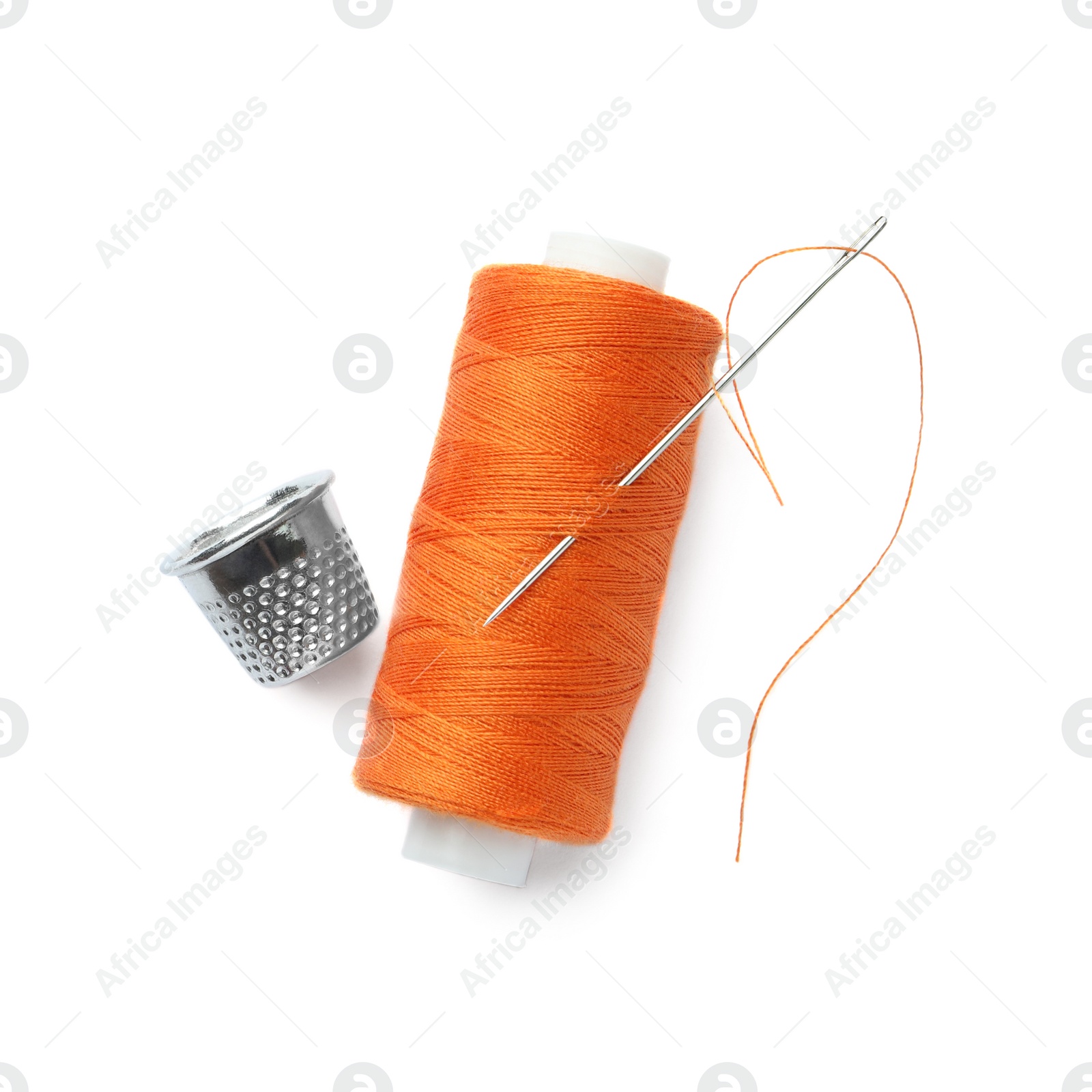 Photo of Spool of orange sewing thread with needle and thimble on white background, top view