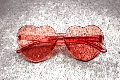 Photo of Pink heart shaped sunglasses on bright background