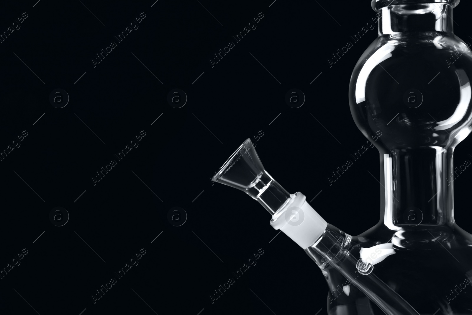 Photo of Closeup view of glass bong on black background, space for text. Smoking device