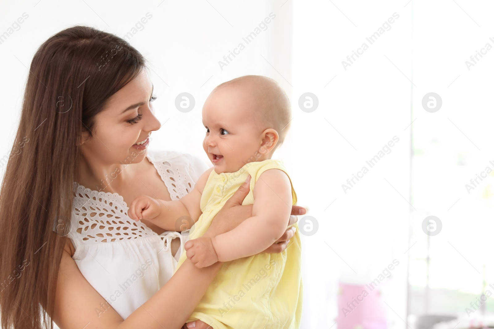 Photo of Young mother with her cute baby girl at home