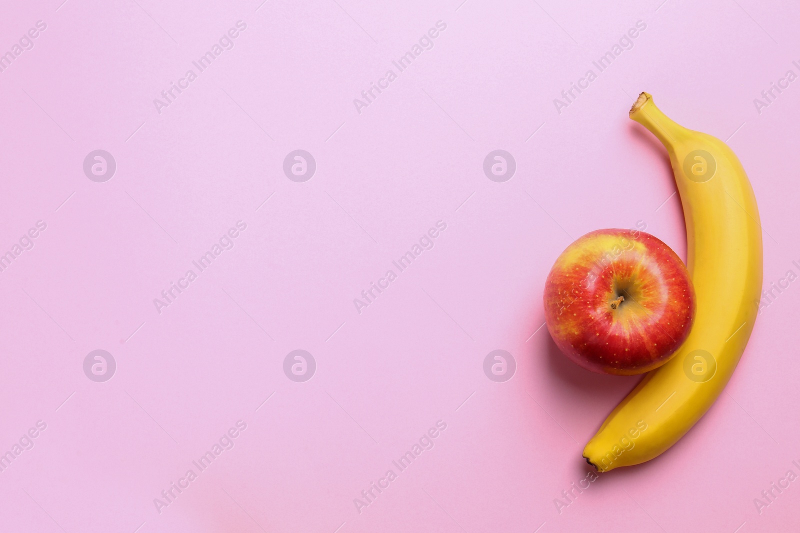 Photo of Tasty raw apple and banana on pink background, flat lay with space for text