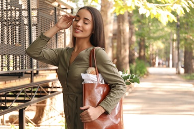 Young woman with leather shopper bag on city street