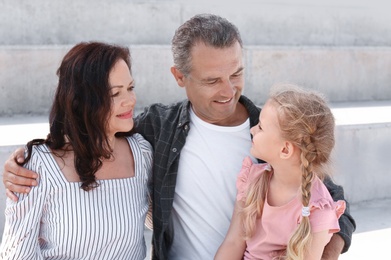 Photo of Couple of pensioners with granddaughter sitting outdoors