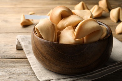 Tasty fortune cookies with prediction on wooden table, closeup