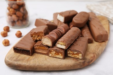 Photo of Pieces of different tasty chocolate bars on white table