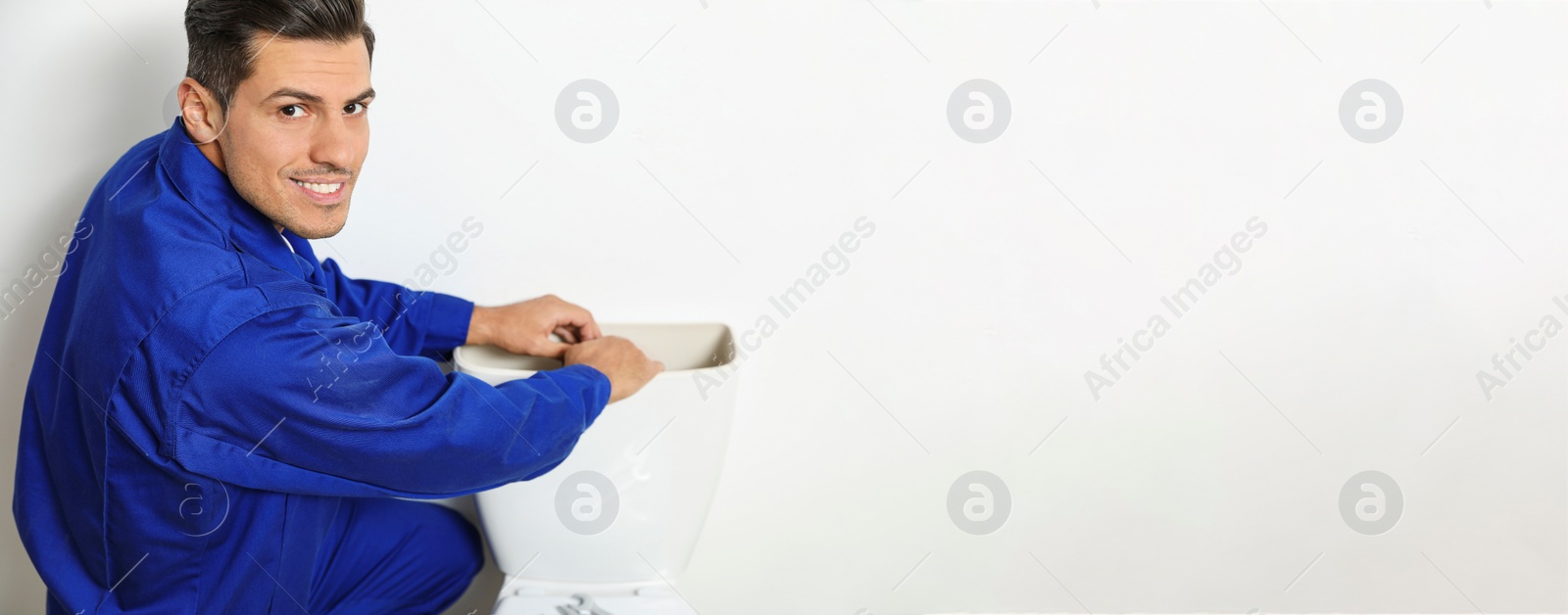 Image of Professional plumber working with toilet bowl in bathroom, space for text. Banner design