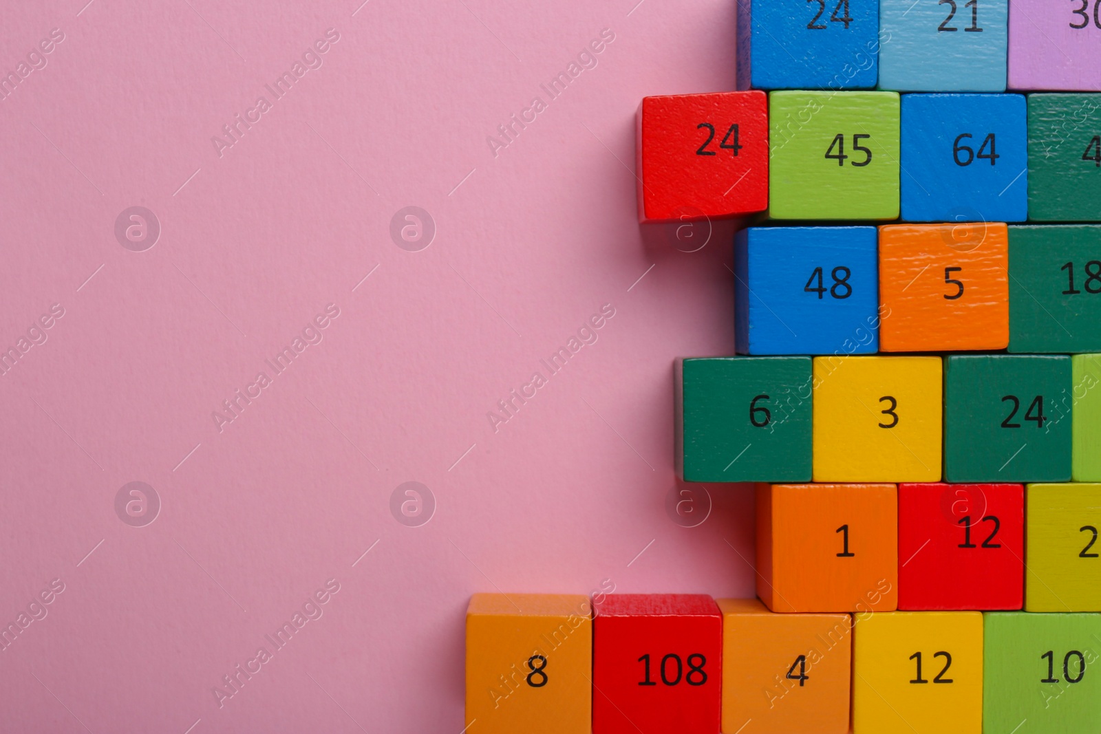 Photo of Wooden cubes with different numbers on light pink background, flat lay. Space for text