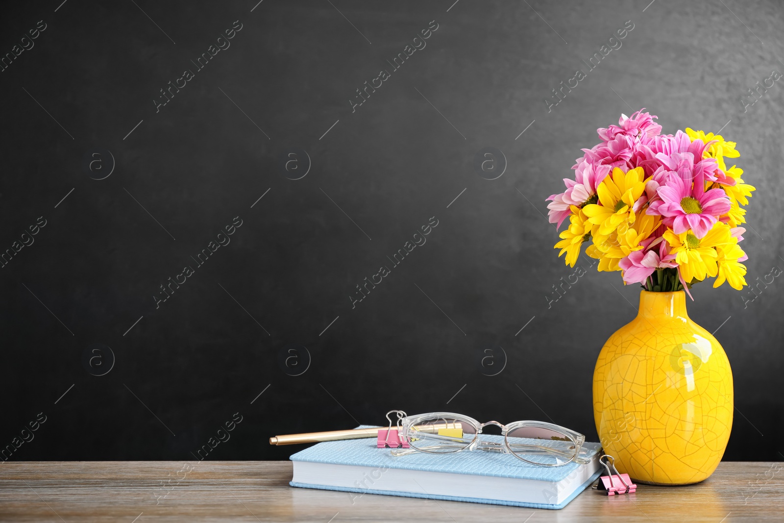 Photo of Bouquet of flowers and notebooks with eyeglasses on table. Teacher day celebration