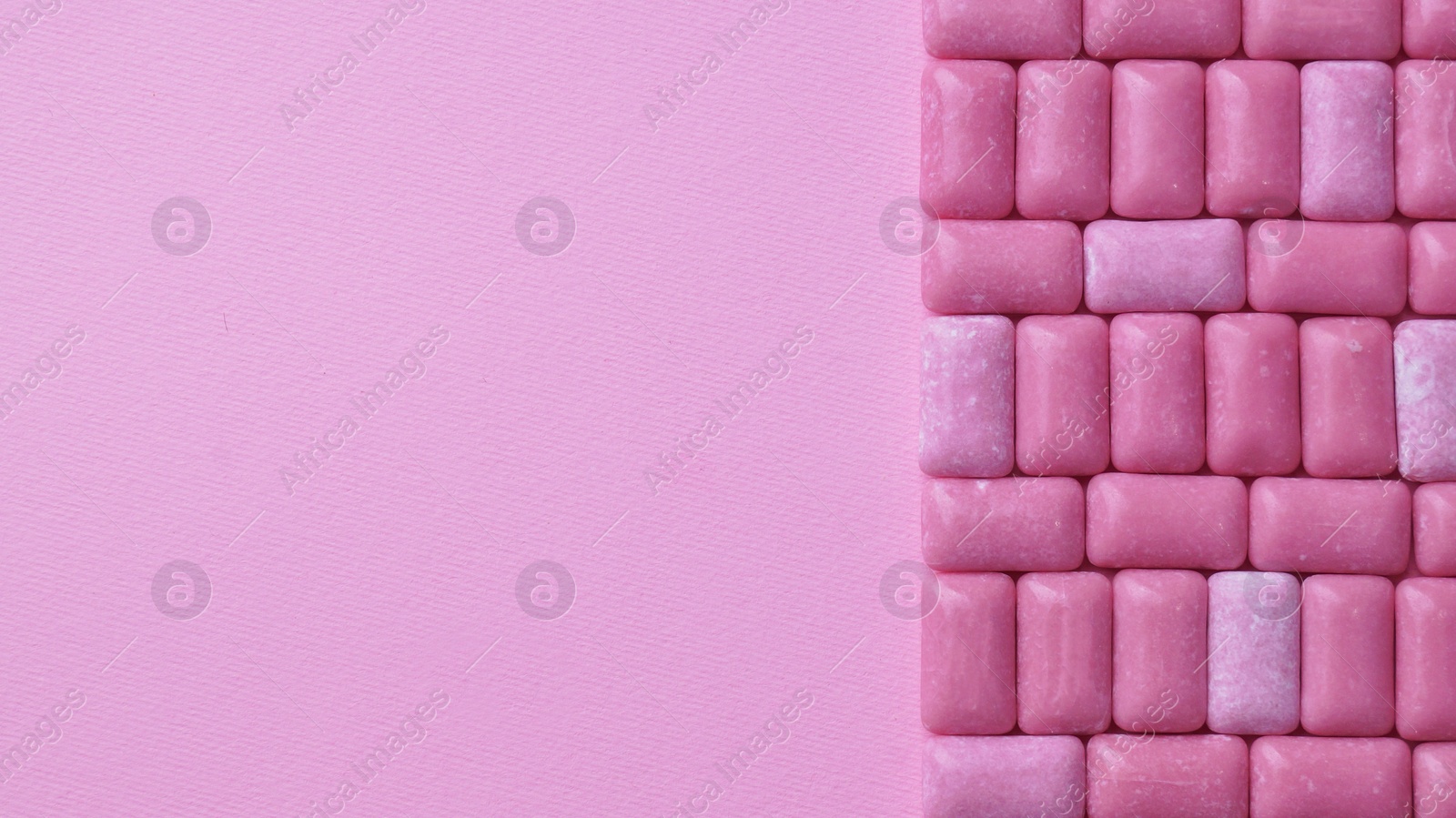 Photo of Many sweet chewing gums on pink background, flat lay. Space for text