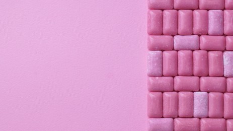 Photo of Many sweet chewing gums on pink background, flat lay. Space for text