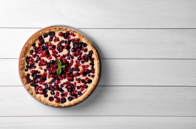 Photo of Delicious currant pie on white wooden table, top view. Space for text