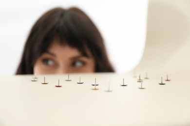 Photo of Young woman near chair with pins, closeup. April fool's day