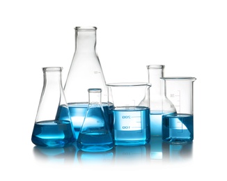Photo of Laboratory glassware with liquid on table against white background. Chemical analysis
