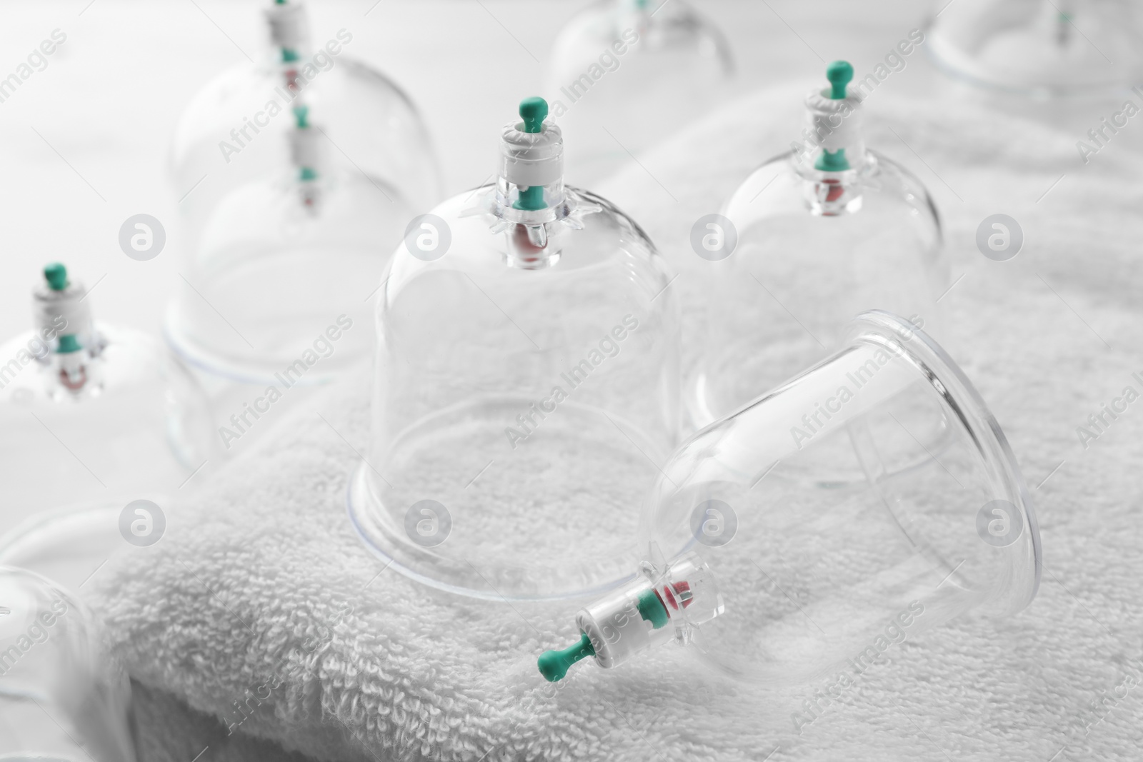 Photo of Plastic cups and towel on table, closeup. Cupping therapy