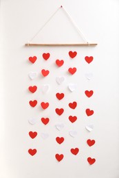 Photo of Beautiful decor element with hearts on white wall. Valentine's Day celebration