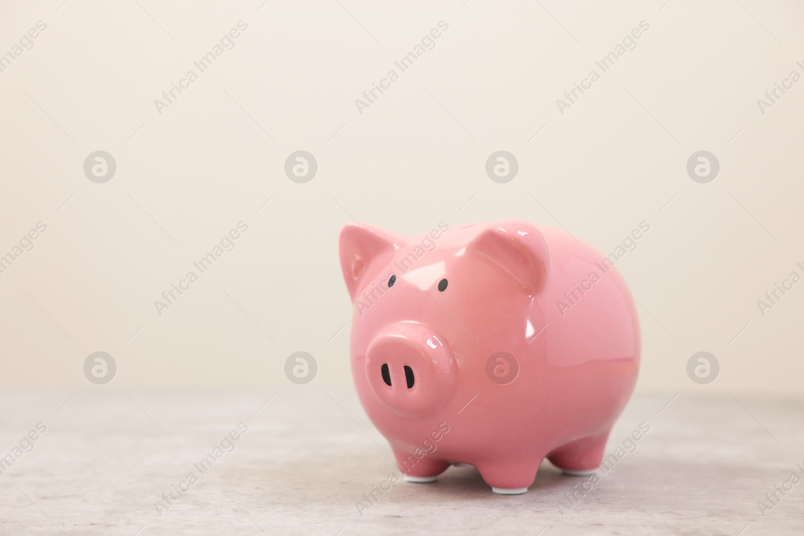 Photo of Pink piggy bank on grey table, space for text