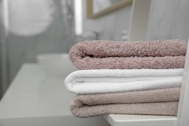 Fresh laundry on table in bathroom, closeup