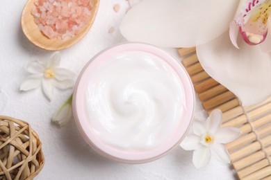 Beautiful spa composition with cosmetic products and flowers on white table, flat lay