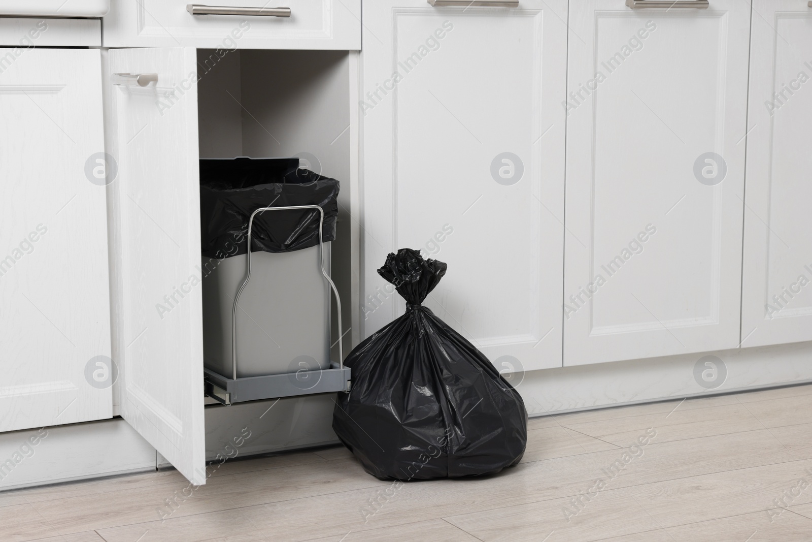 Photo of Plastic garbage bag and trash can indoors. Space for text