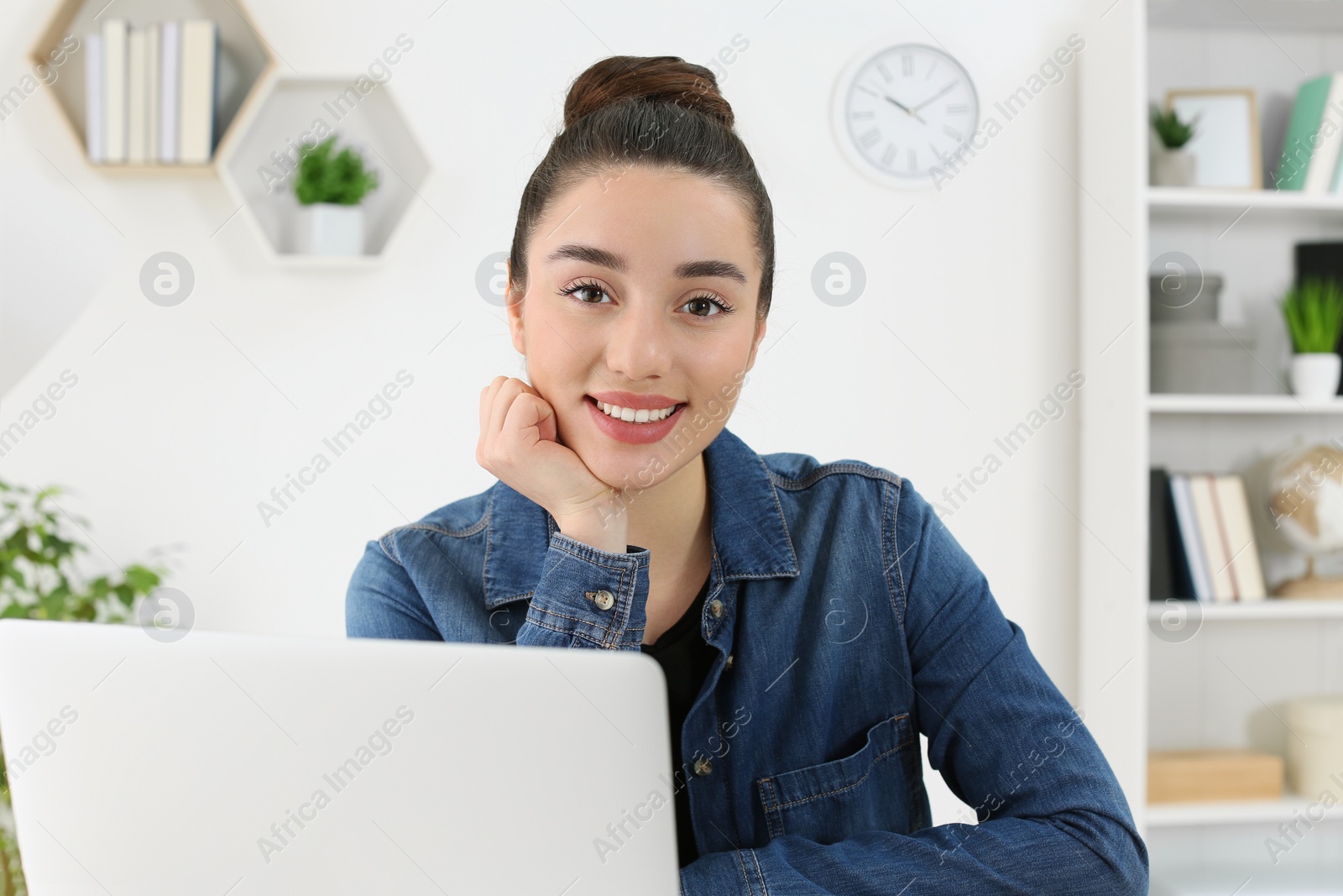 Photo of Home workplace. Portrait of happy woman near laptop in room