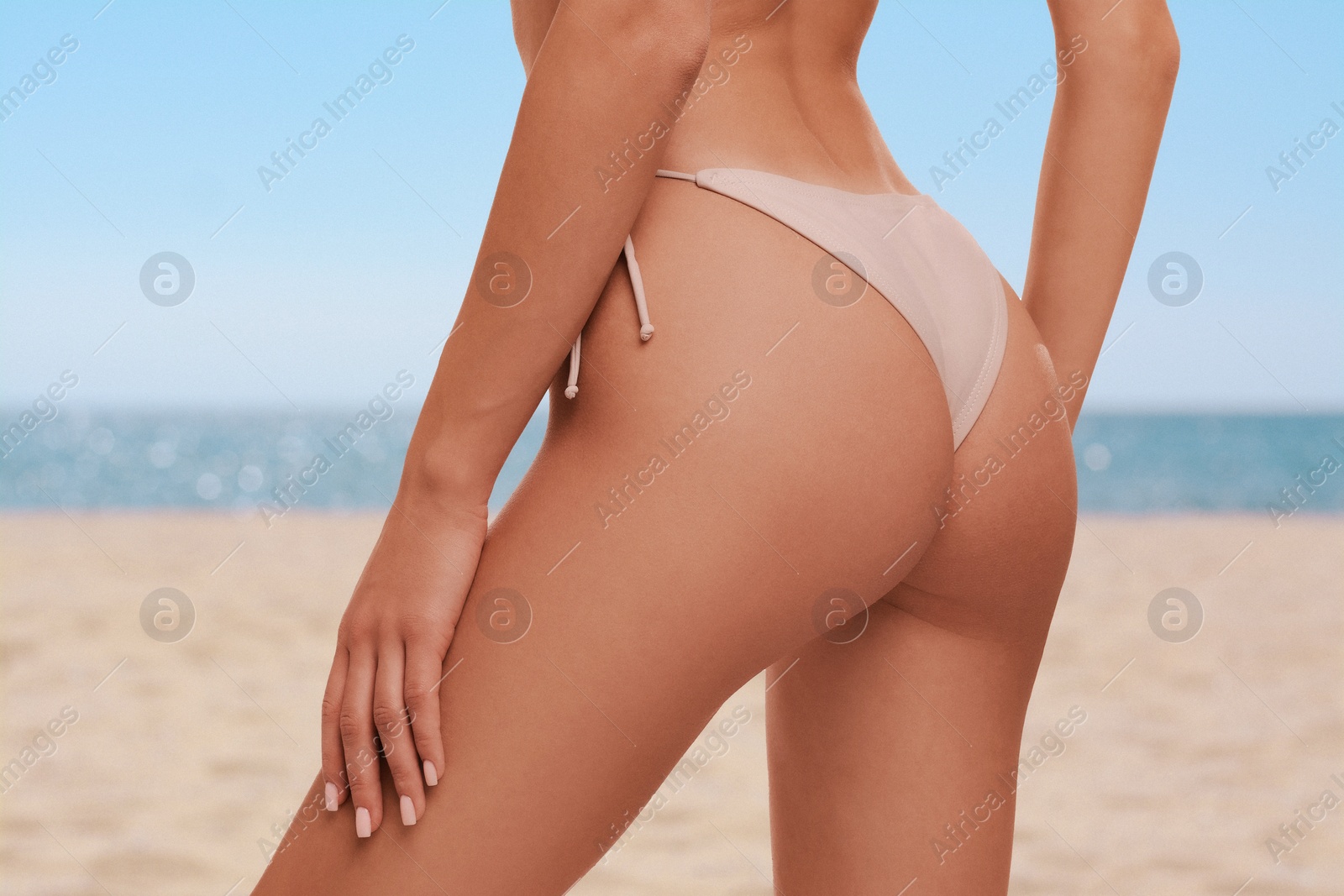 Image of Woman in stylish bikini on sandy beach near sea, closeup