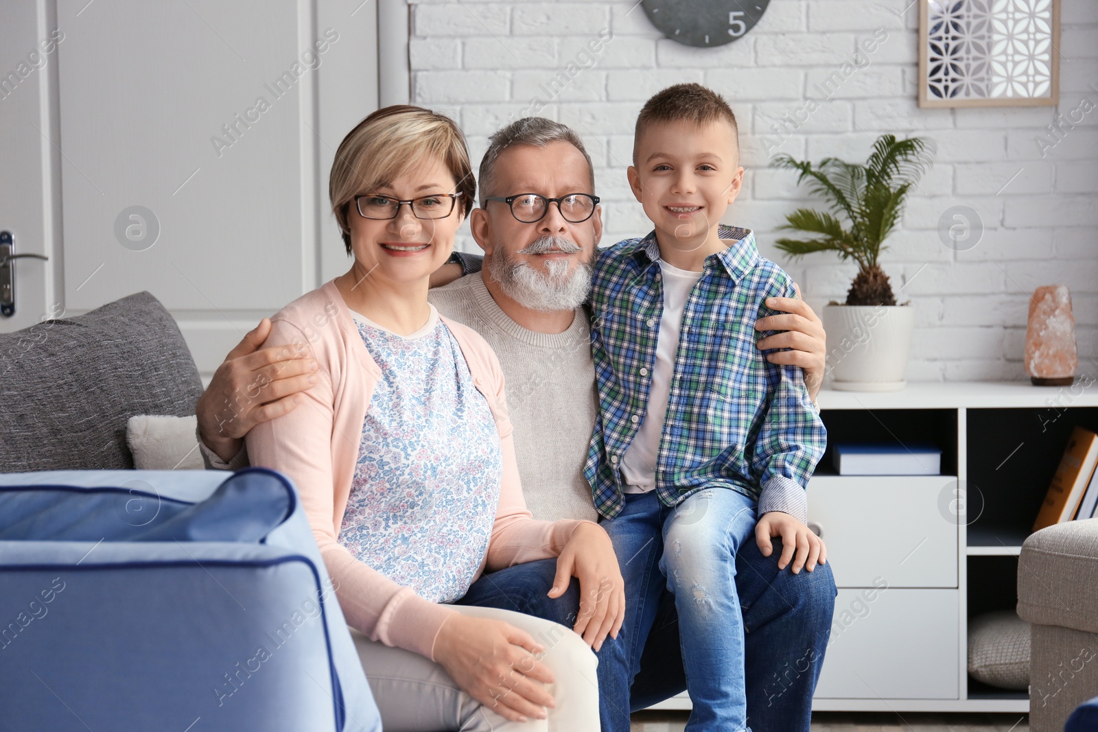 Photo of Happy senior couple with little grandson at home