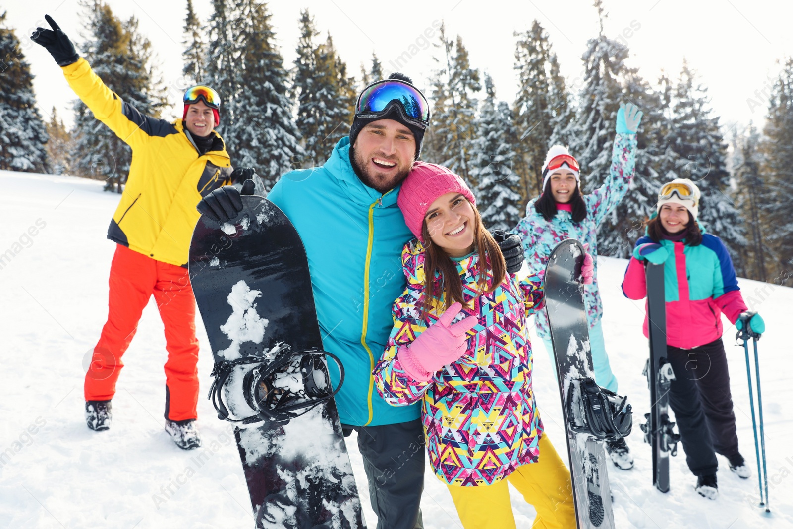 Photo of Happy couple with friends on snowy slope. Winter vacation