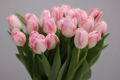 Photo of Beautiful bouquet of fresh pink tulips on light grey background, closeup