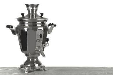 Photo of Traditional Russian samovar on wooden table against white background. Space for text