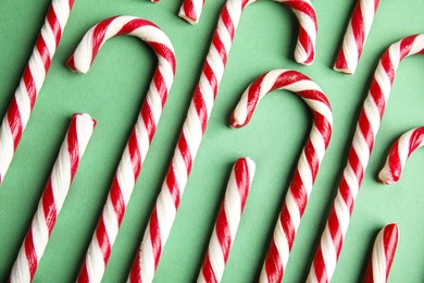 Photo of Candy canes on green background, flat lay