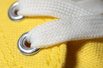 Texture of yellow sneaker with laces, macro view