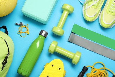 Photo of Different sports equipment on light blue background, flat lay
