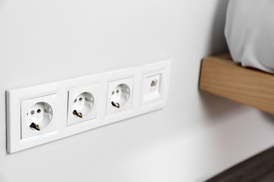 Photo of Power sockets on white wall indoors, closeup. Electrical supply