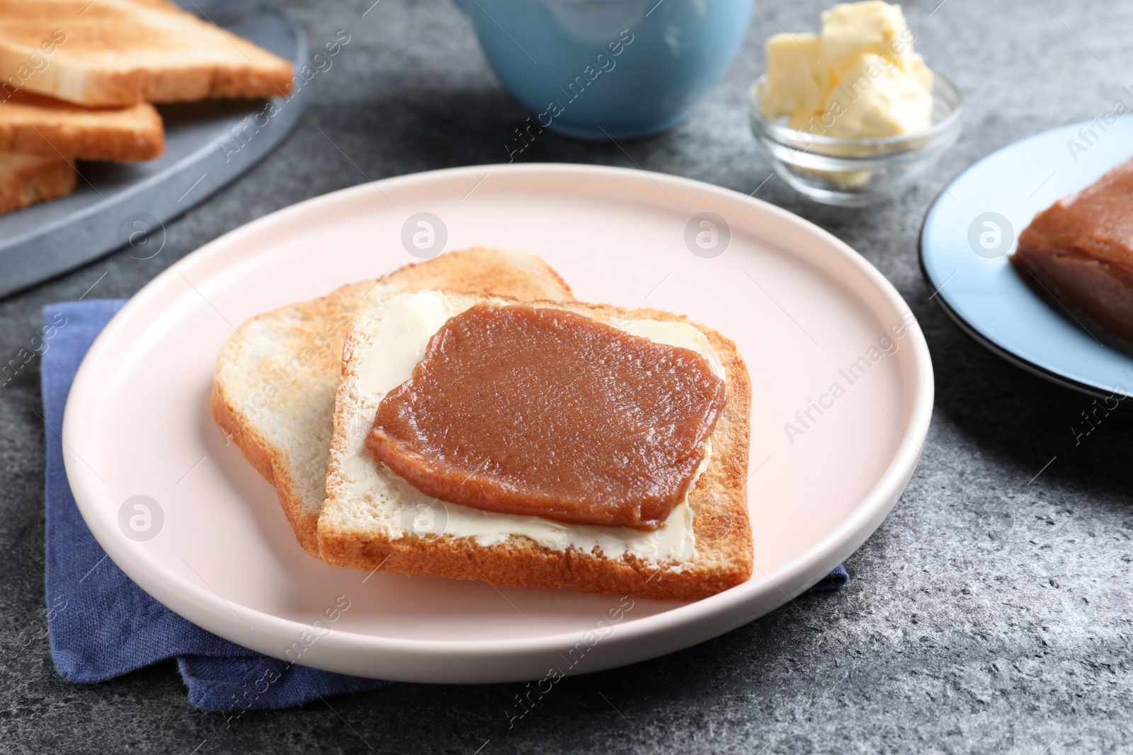 Photo of Tasty sandwich with quince paste served for breakfast on grey table, closeup