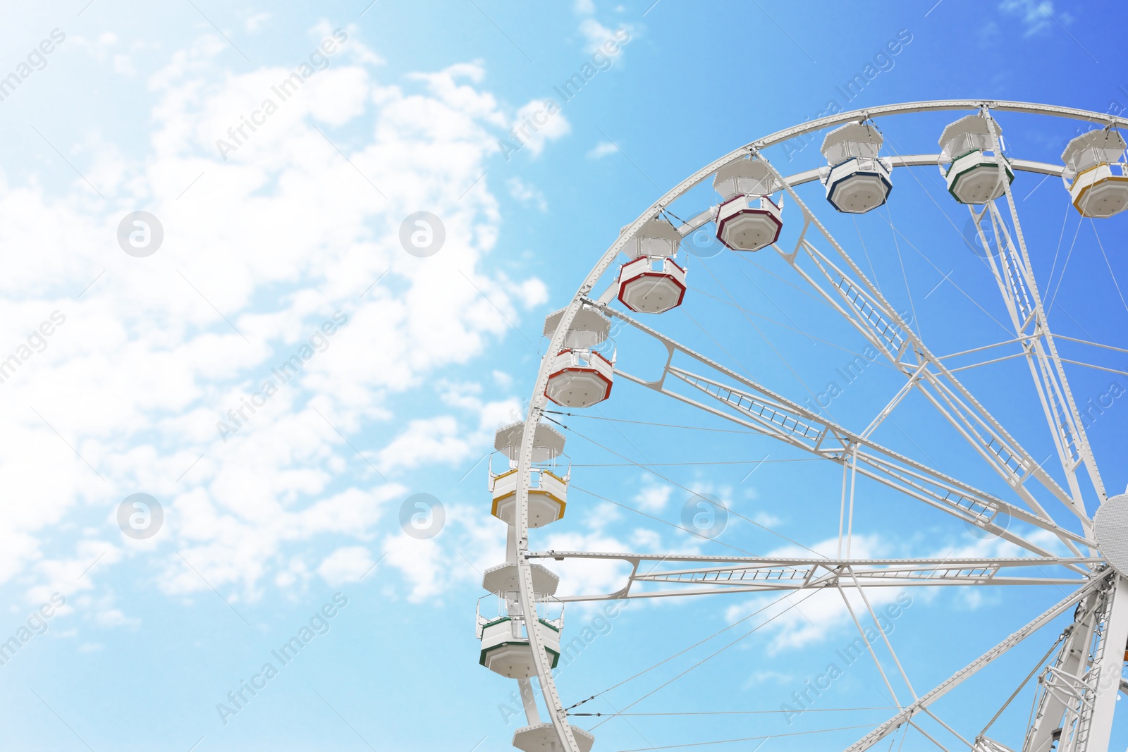 Photo of Large white observation wheel against sky, space for text