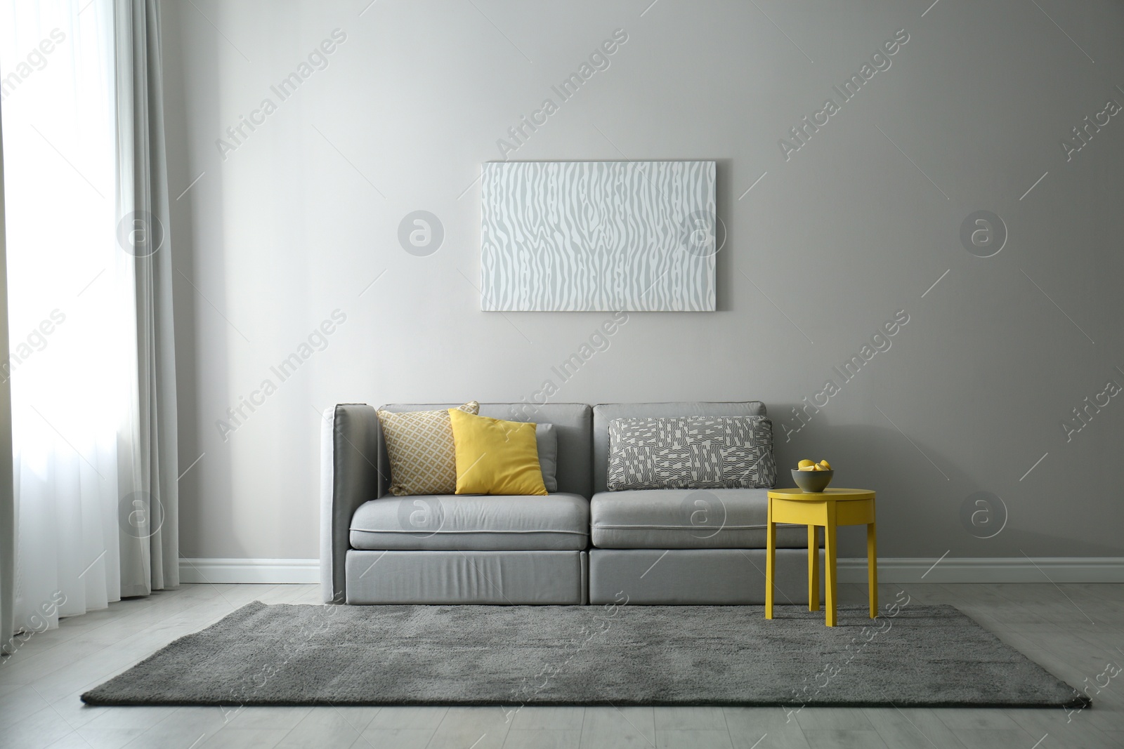 Photo of Stylish living room with sofa. Interior design in grey and yellow colors