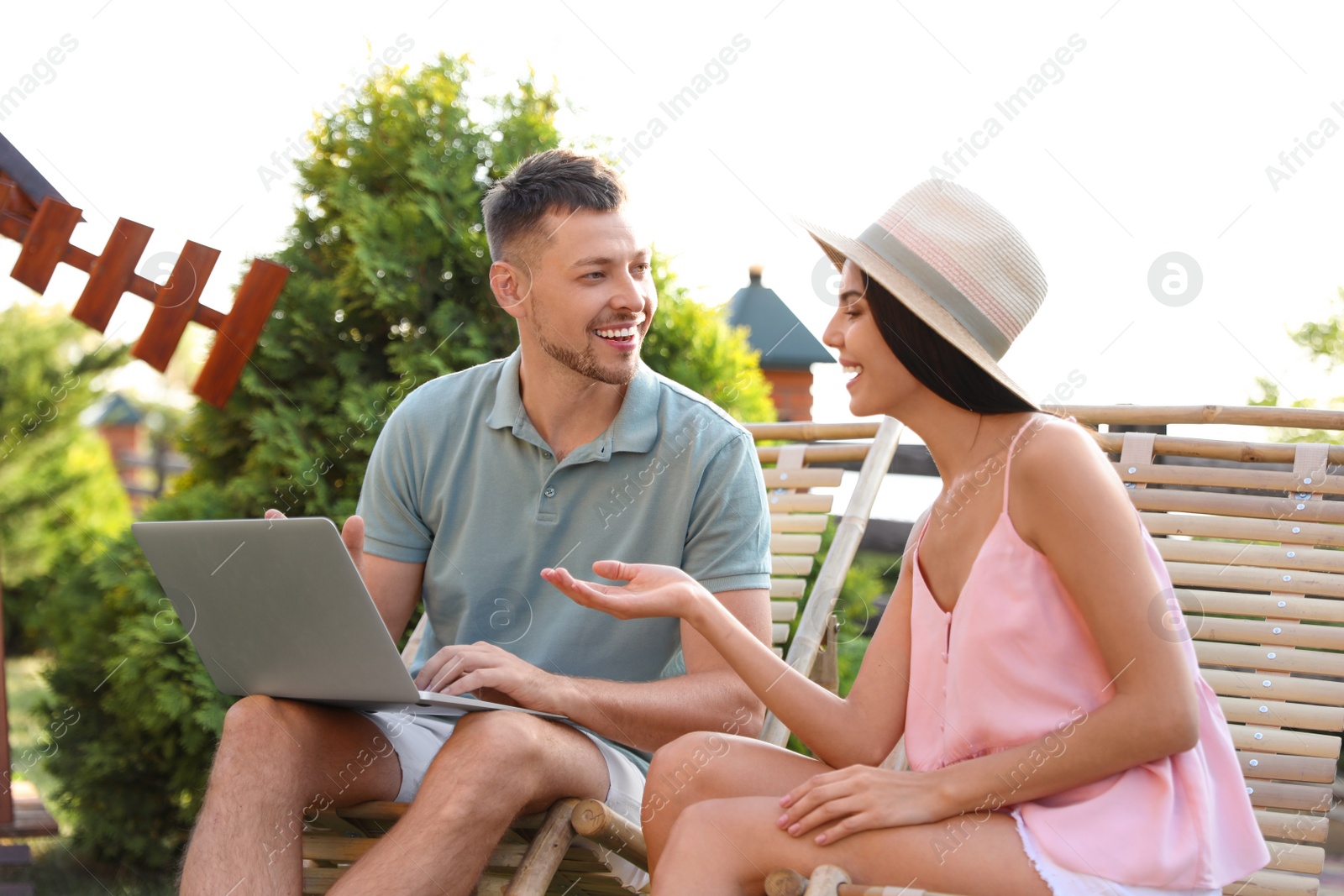 Photo of Happy couple relaxing in deckchairs at backyard