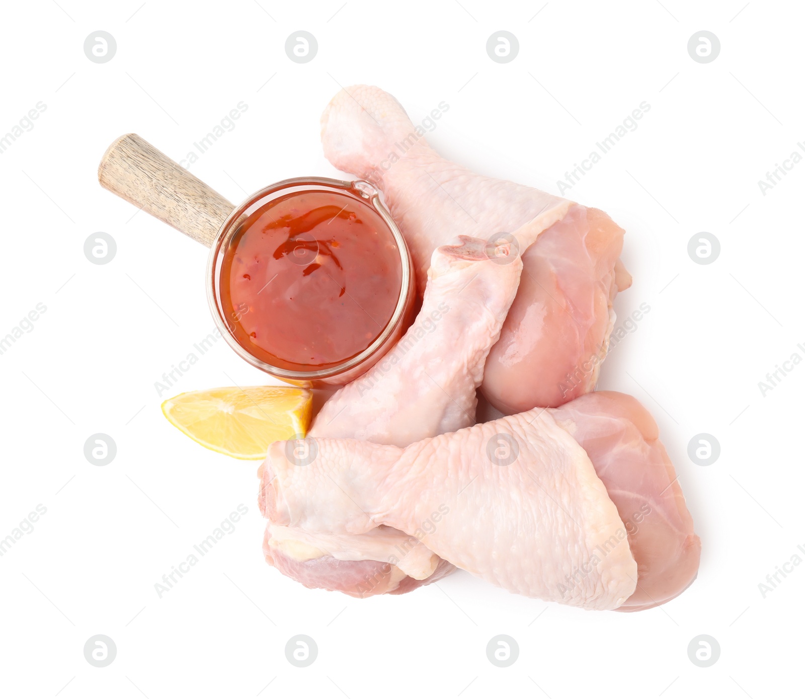 Photo of Fresh marinade, raw chicken drumsticks and lemon wedge isolated on white, top view