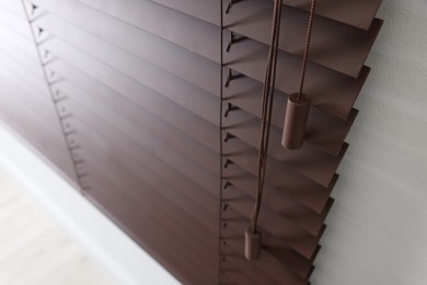 Photo of Stylish horizontal window blinds on white wall indoors, closeup