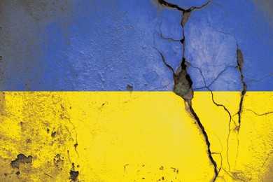 National flag of Ukraine painted on old cracked wall