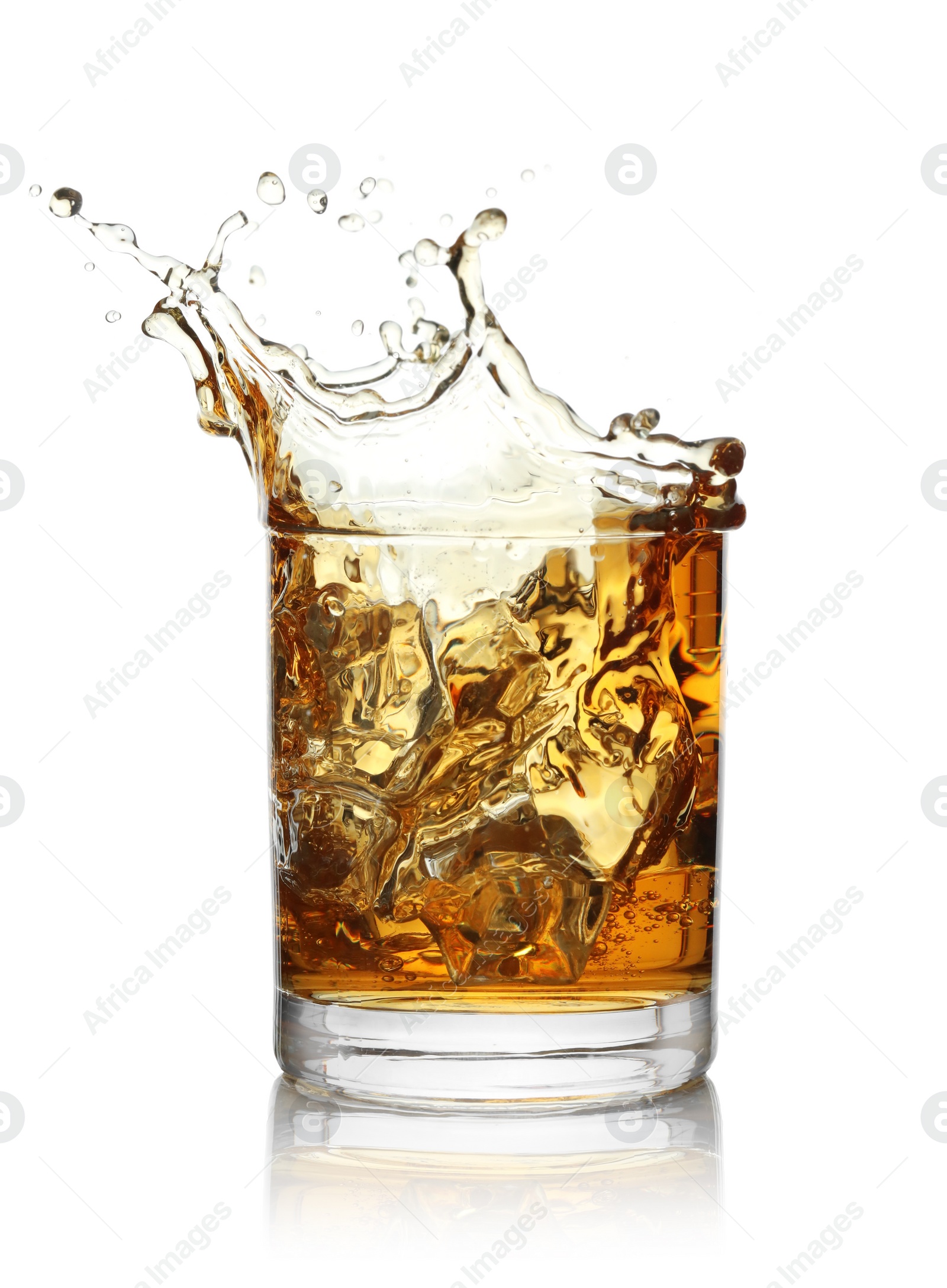 Photo of Whiskey splashing out of glass on white background