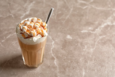 Photo of Glass with delicious caramel frappe on grey background