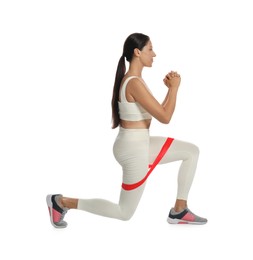 Woman doing lunges with fitness elastic band on white background