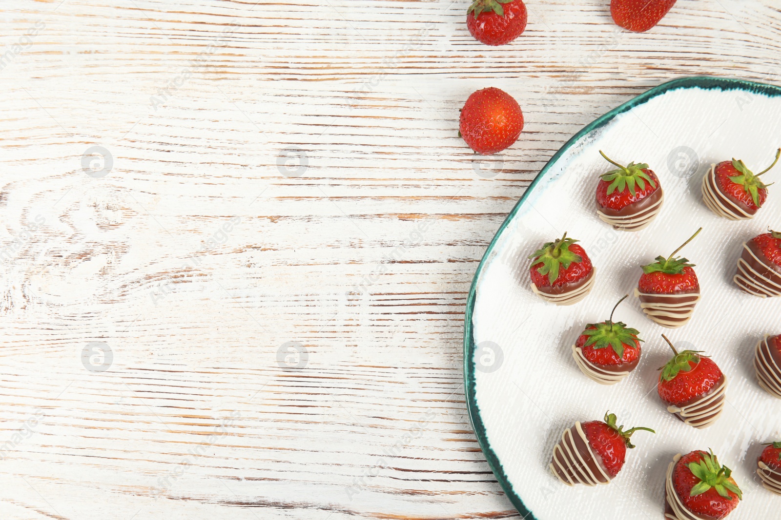 Photo of Plate with chocolate covered strawberries on wooden background, top view