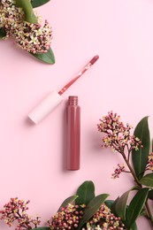 Bright lip gloss, applicator and flowering branches