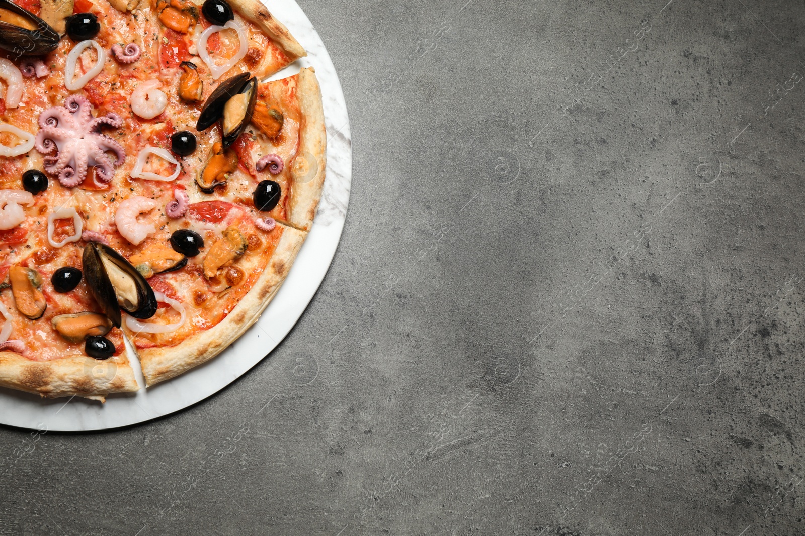 Photo of Delicious seafood pizza on grey table, top view. Space for text