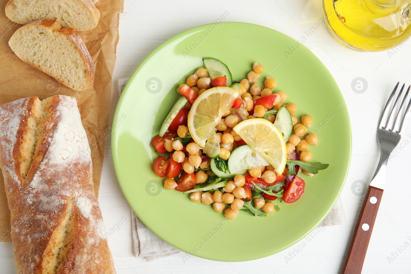 Photo of Delicious fresh chickpea salad served on white wooden table, flat lay